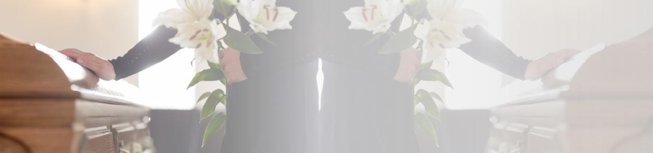 the image contains a person in a funeral home with bouquets of flowers