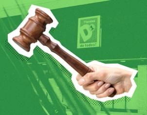 Una mano sostiene un mazo de madera (mallete) en primer plano sobre un fondo verde donde se aprecia el logotipo de Tiendas D1.