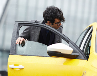 Se muestra a un hombre con gafas tomando un taxi