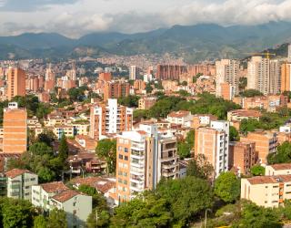 Imagen de vista panorámica de Medellín con edificios y montañas.