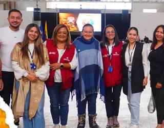 Grupo de personas y en el lado izquierdo vaca con productos lácteos.