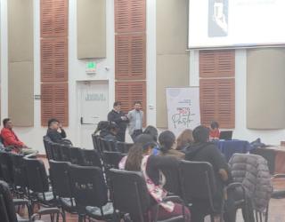 Imagen contiene fotografía de personas al interior de un auditorio.