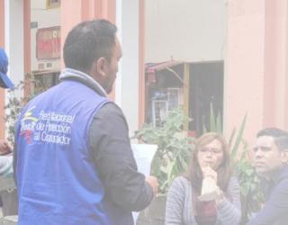 Imagen contiene fotografía de funcionarios de la RNPC ofreciendo orientación a los consumidores en un espacio público.