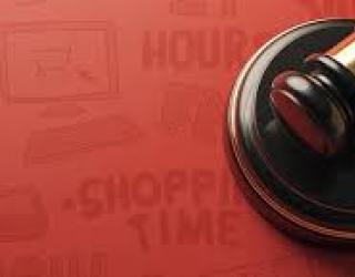 Primer plano de un mazo o martillo de juez sobre un fondo rojo.