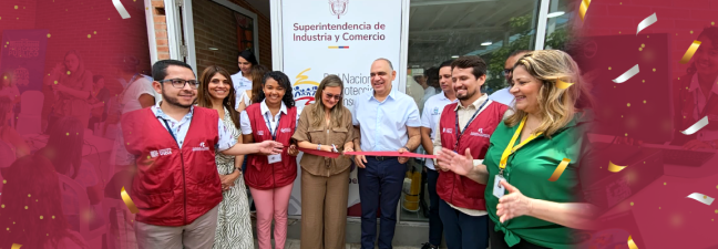 Un grupo de personas sonrientes cortando una cinta roja frente a un cartel de la "Superintendencia de Industria y Comercio". A la izquierda, un ícono de ubicación con una casa.